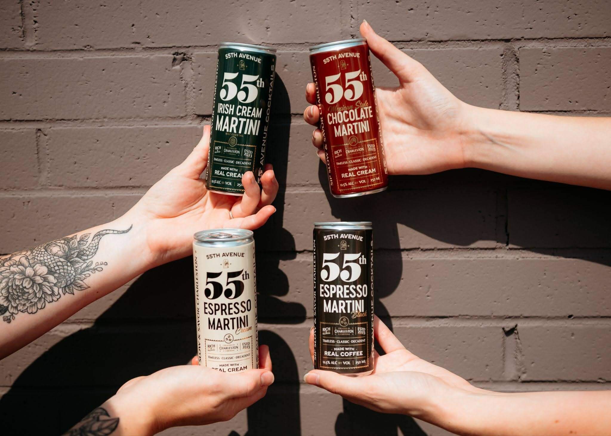 Hands holding out cans of 55th Avenue Cocktails